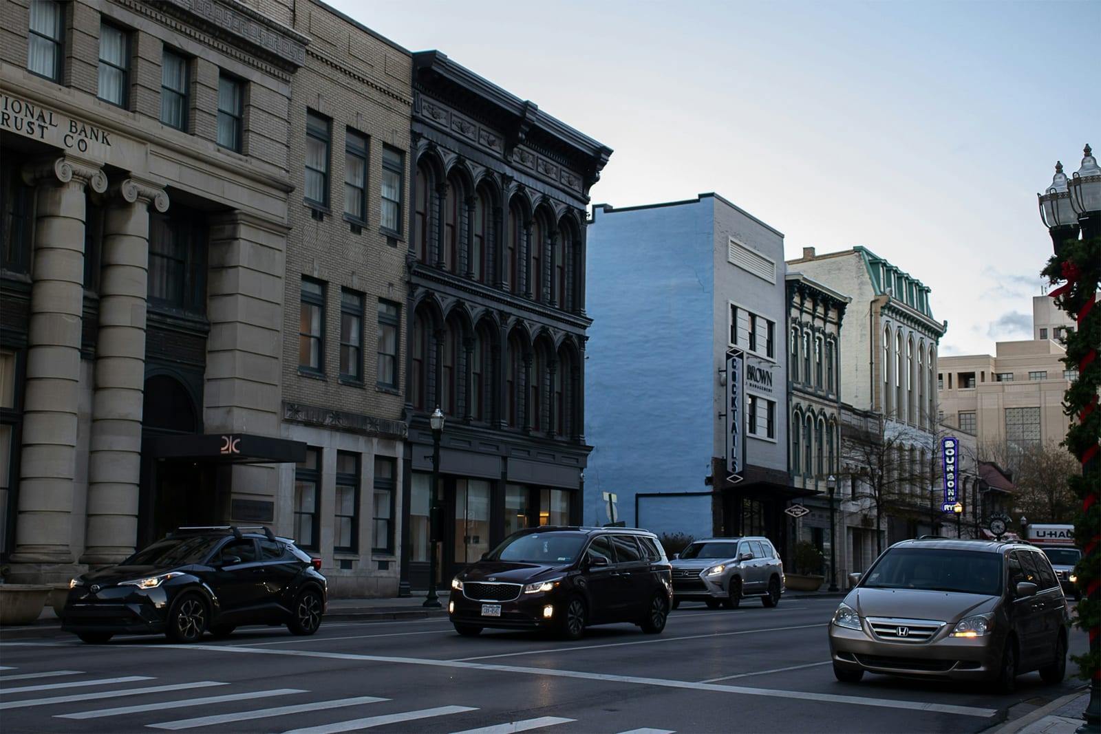 Historic storefronts and evening traffic along Main Street in downtown Lexington, Kentucky.